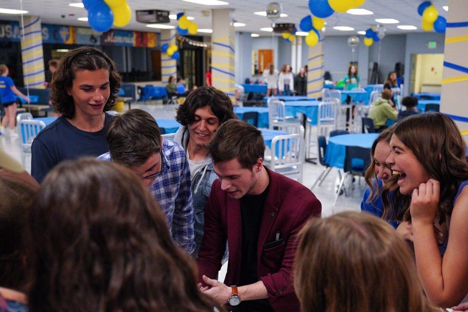 Guests reacting to close-up magic during a cocktail hour — available in Kansas City