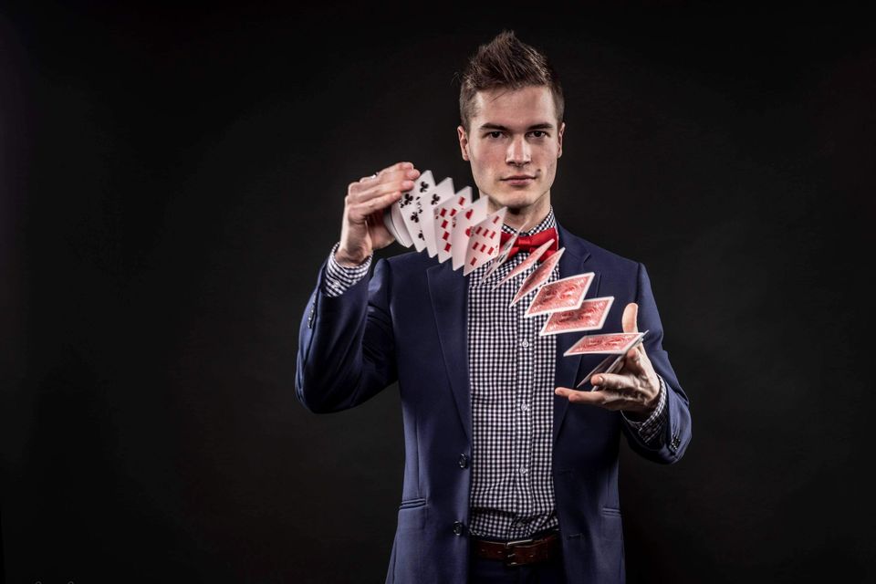 Caleb Hyatt performing close-up magic for guests at a reception — available in Des Moines