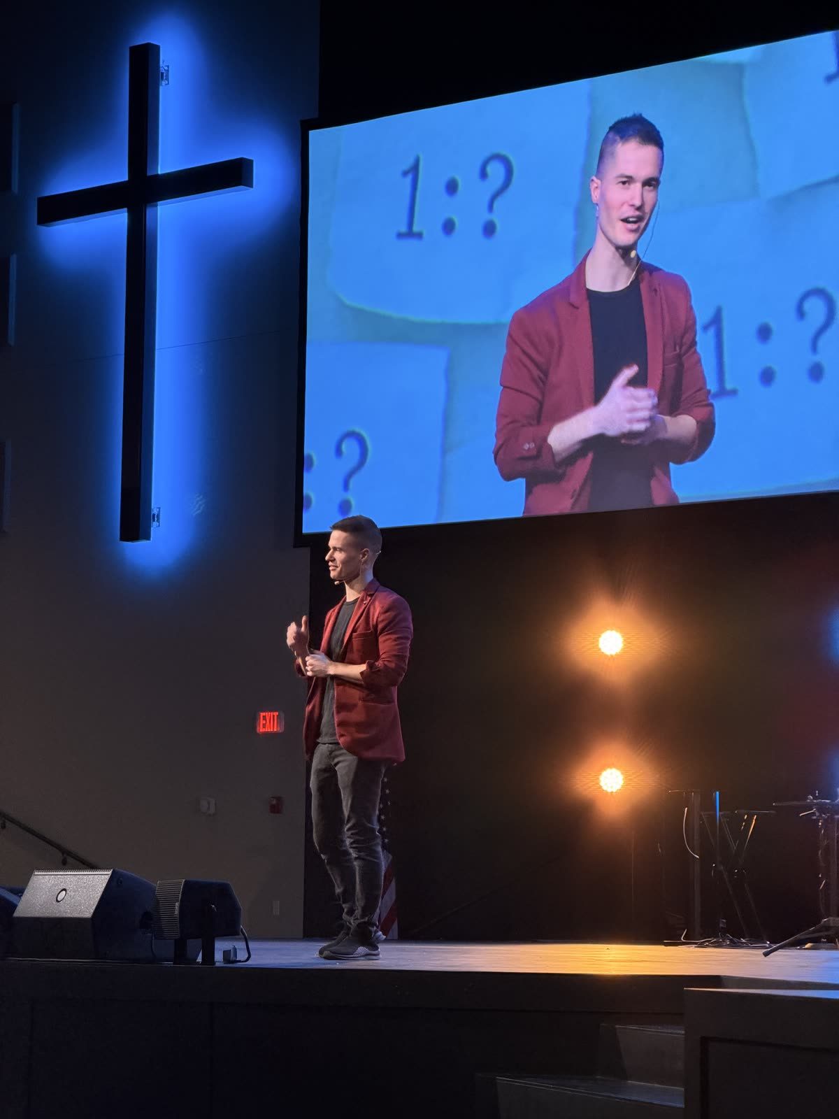 Caleb Hyatt performing the What Are the Odds gospel show beneath a glowing cross