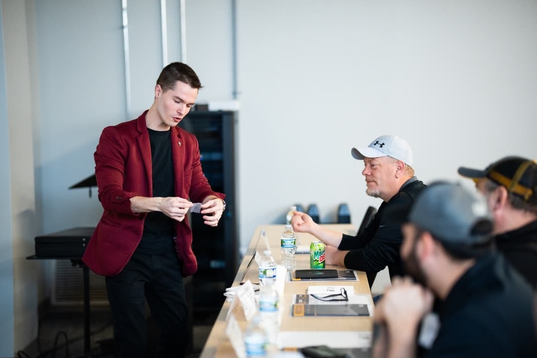 Caleb Hyatt performing close-up magic at a corporate conference