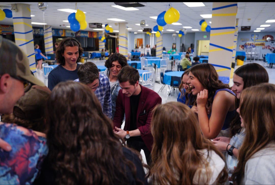 Students reacting to Caleb Hyatt's magic at a school event